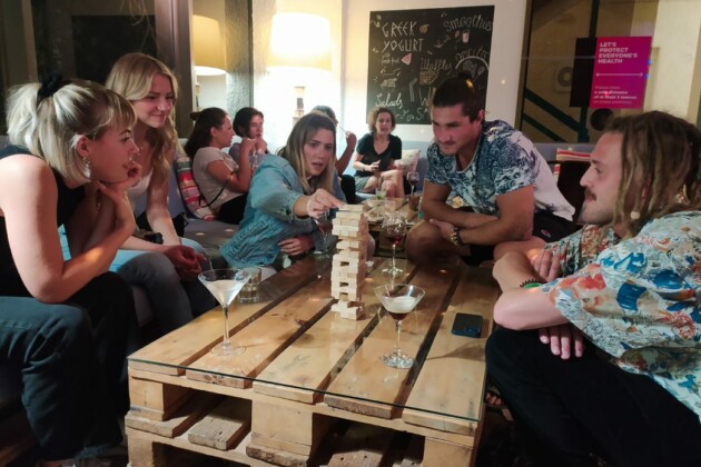 board game night travellers playing jenga and drinking cocktails and wine in stay hostel bar rhodes