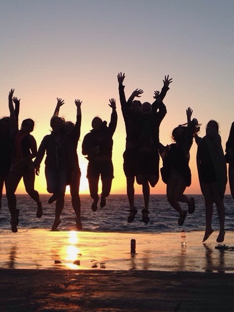 group of stay travelers having fun enjoying beautiful rhodian sunset at the beach