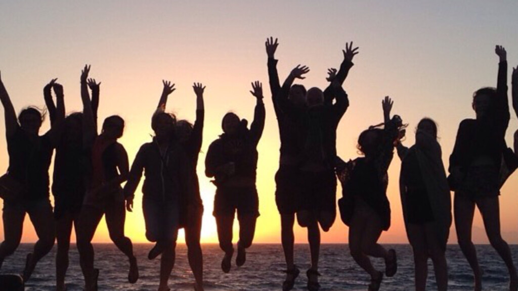 international group of travelers, backpackerss, digital nomads and alternative tourists jumping in sunset in rhodes